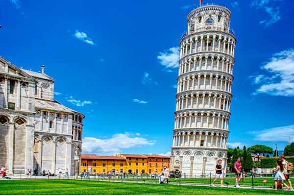 In the background, the iconic Leaning Tower of Pisa stands tall against a backdrop of clouds and open sky