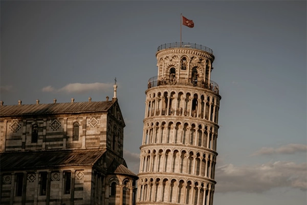 The Leaning Tower of Pisa with a cinematic effect, surrounded by flags.