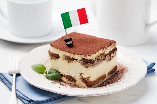 Tiramisu, traditional Italian dessert on a white plate with Italian flag